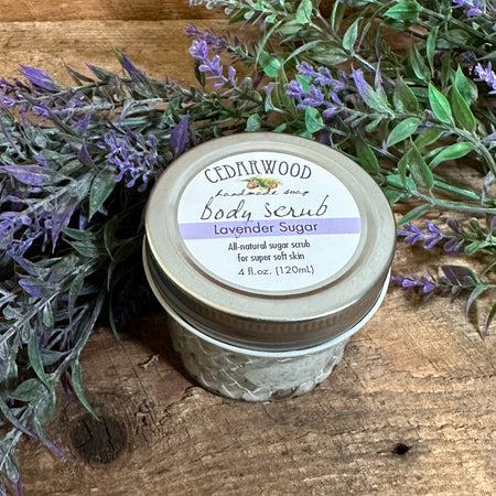 Glass jar of Lavender Sugar body scrub with lavender branches in the background