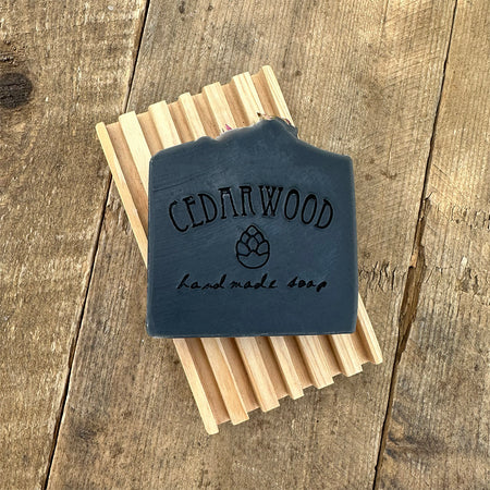 Tea tree charcoal handmade soap bar on wood soap dish