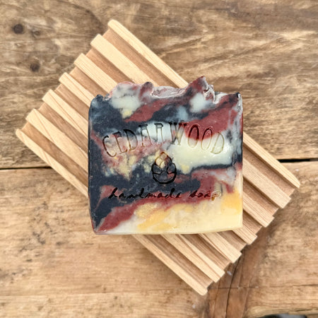 Bar of Maryland-themed handmade soap on wood soap dish