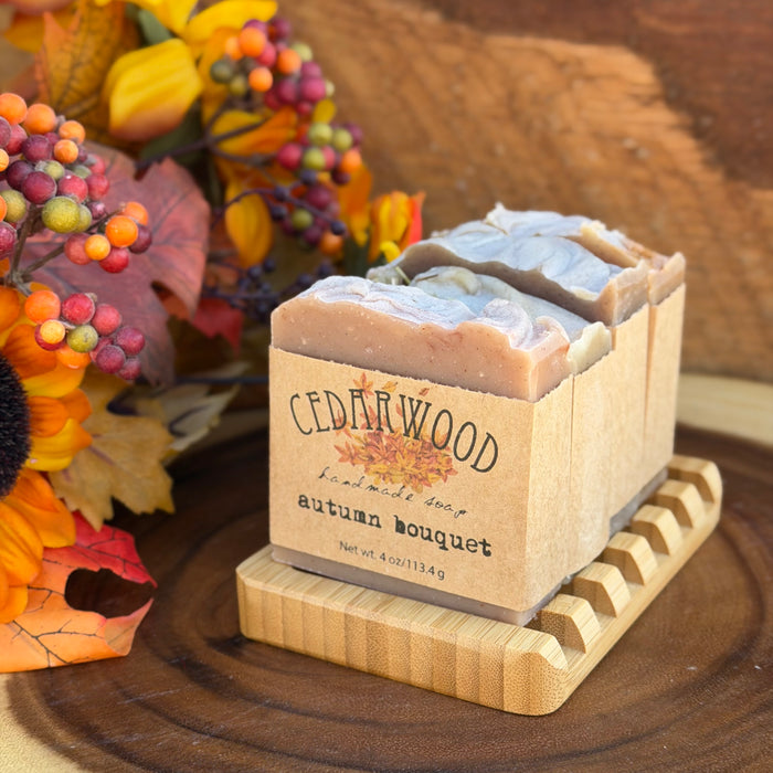 Four handmade fall soaps on bamboo soap with with fall decor