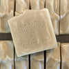 Handmade bar of Patchouli soap with Cedarwood Soap logo with soap bars in background